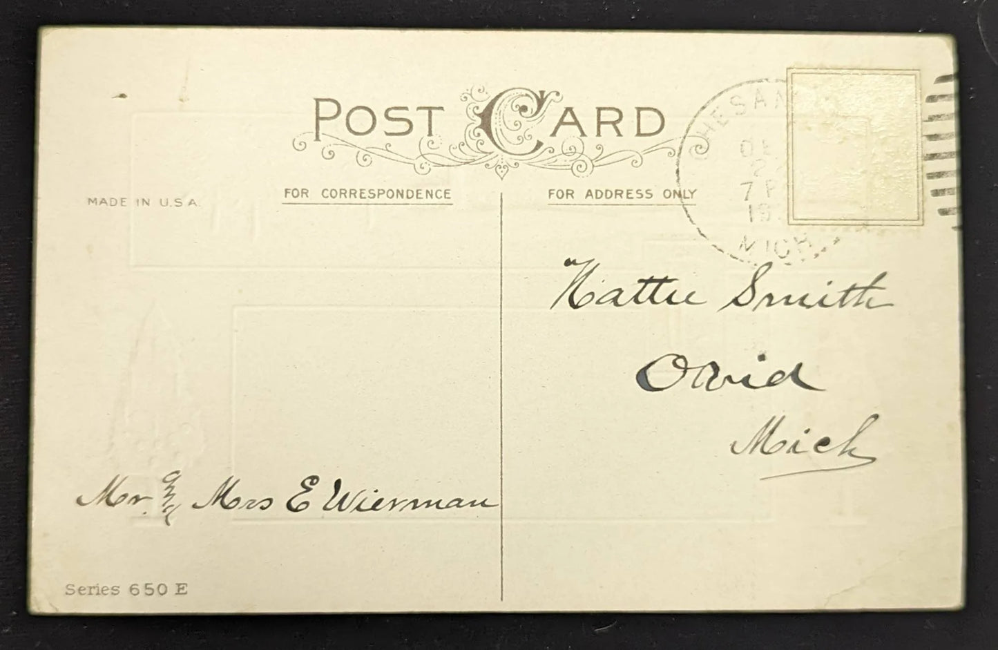 Vintage postcard with handwritten address on a black background