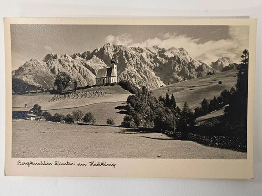 Vintage black and white photo of a mountain landscape with a church and fields.