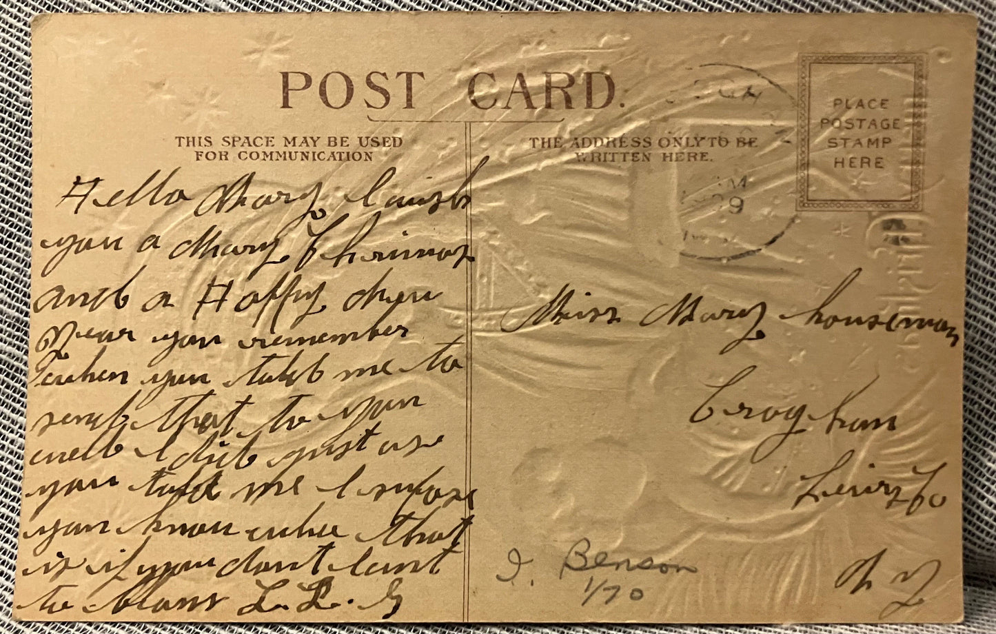 Vintage postcard with handwritten text and postage stamp on a textured surface