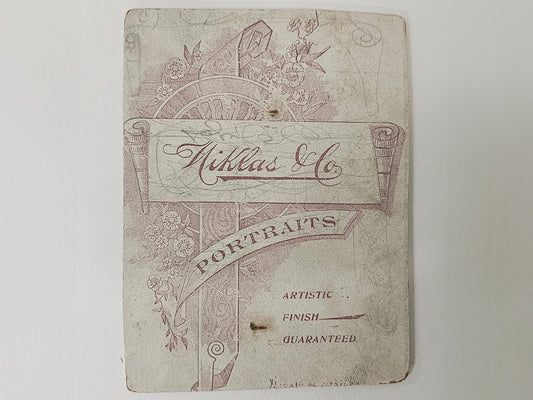 Vintage photograph back with decorative text and design on a white background