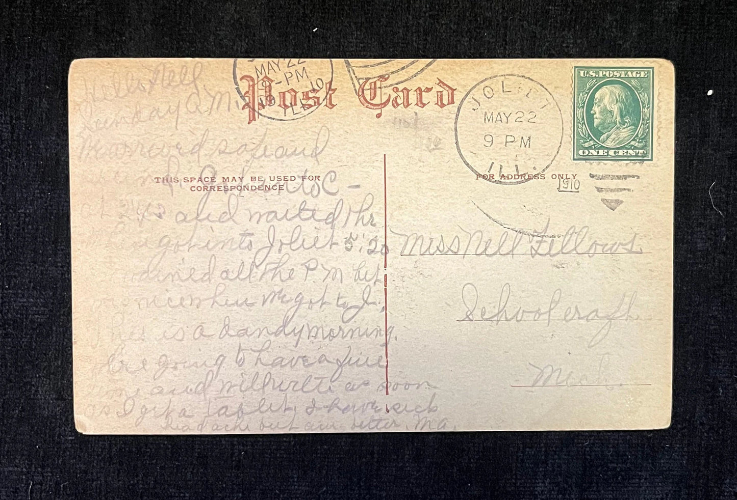 Vintage postcard with handwritten text and a stamp on a dark background