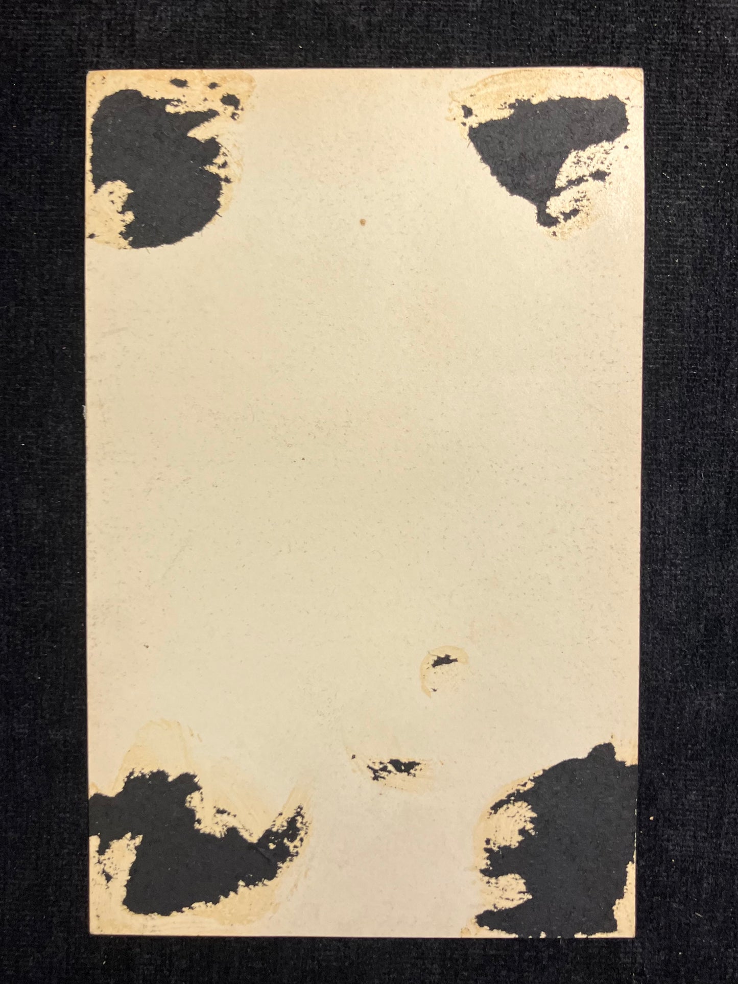 Vintage card with black ink blots on a black background