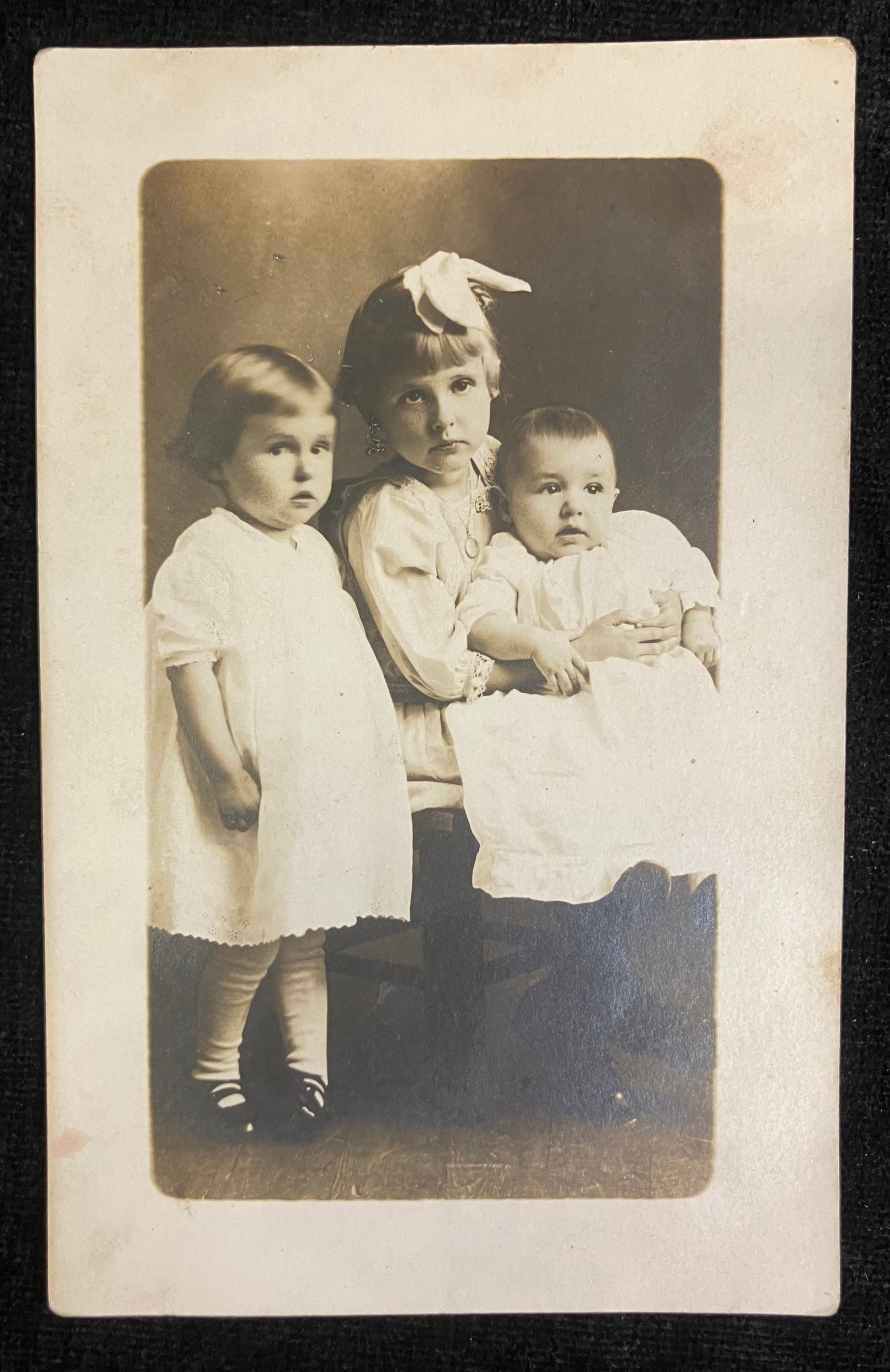 Vintage photograph of three children sitting together