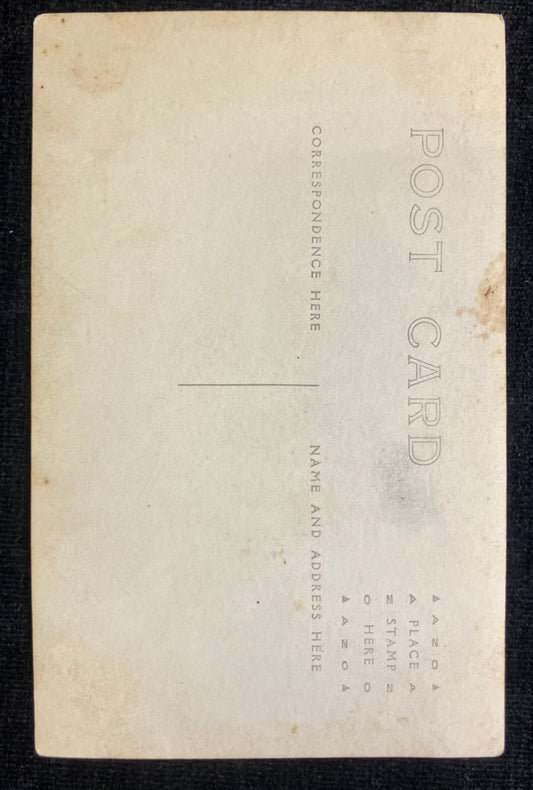 Back of a vintage postcard with typewritten instructions on a black background