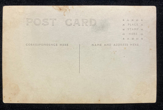 Back of a vintage postcard with typewritten instructions on a black background