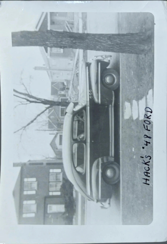 Vintage black and white photo of a car with 'Hacks '47 Ford' text.