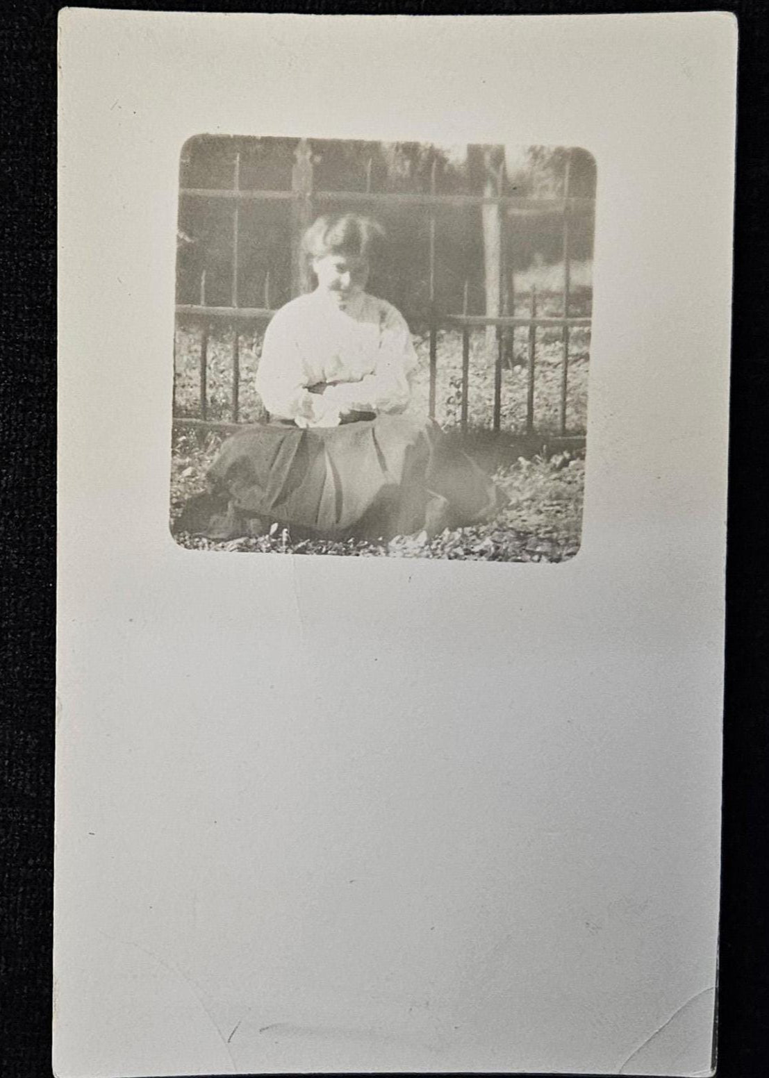 RPPC - Portrait of Smiling Teenage Girl - In Victorian Clothing by Iron Fence - Bashful Teen Posing in Bright Sunshine Real Photo Postcard