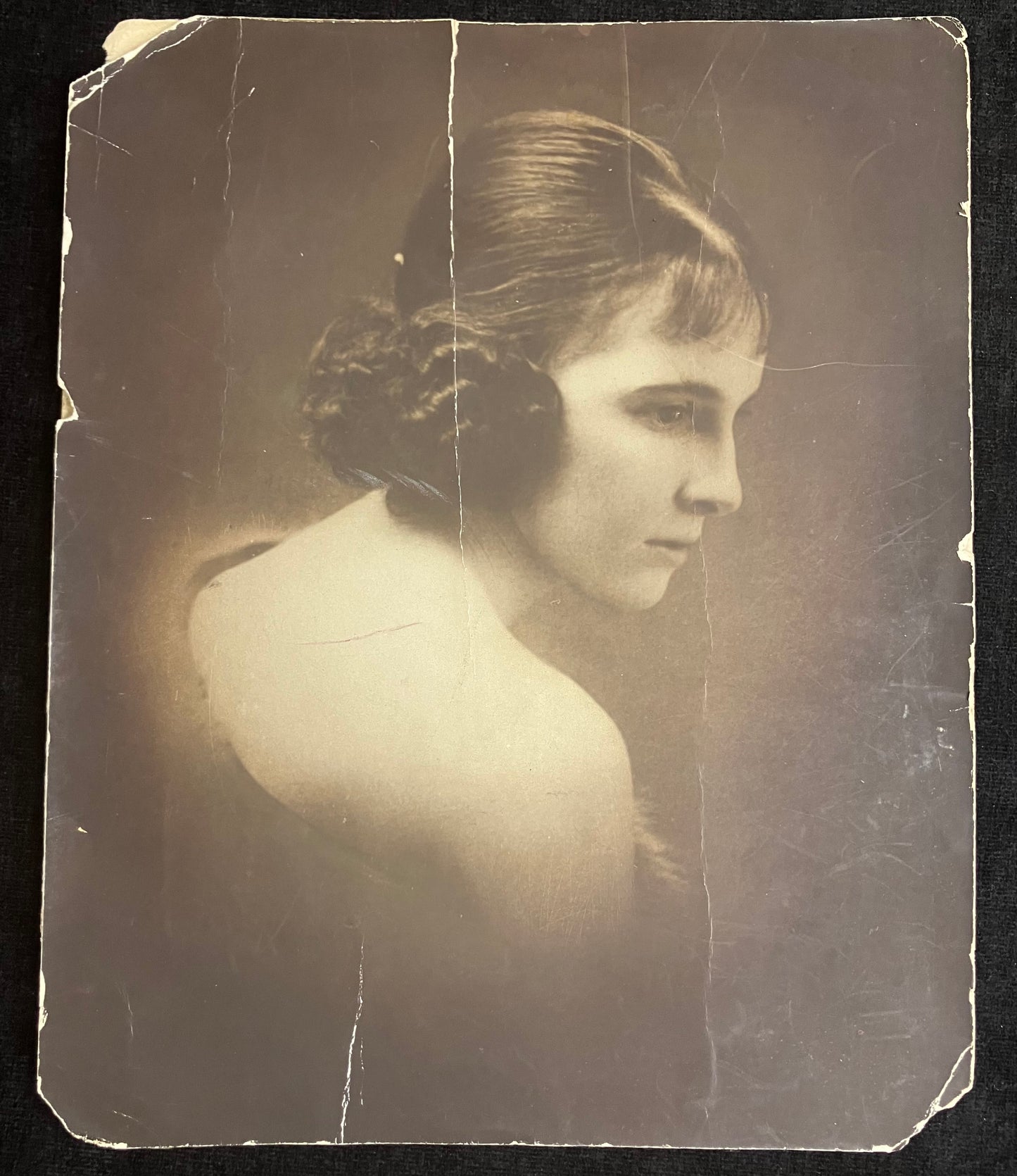 Vintage sepia-toned portrait of a woman with a dark background