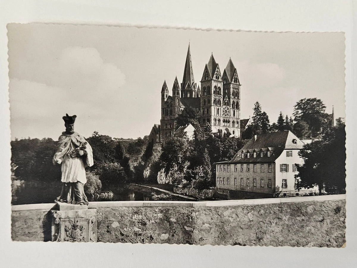 Vintage black and white photograph of a castle with a statue in the foreground