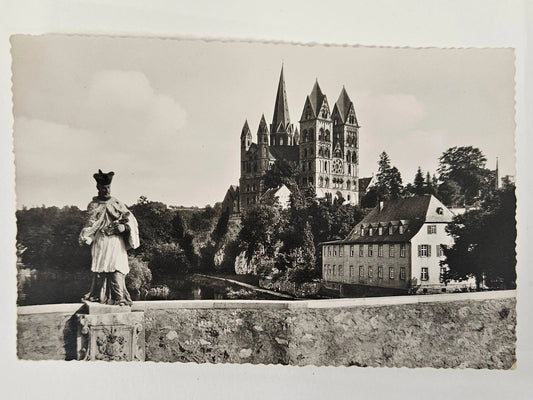 Vintage black and white photograph of a castle with a statue in the foreground