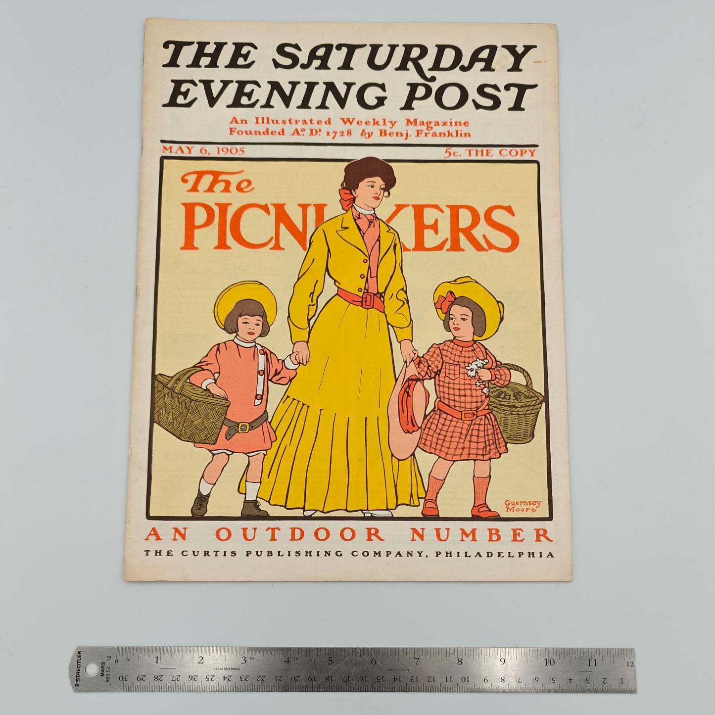 Vintage magazine cover of 'The Saturday Evening Post' with a woman and two children, ruler for scale.