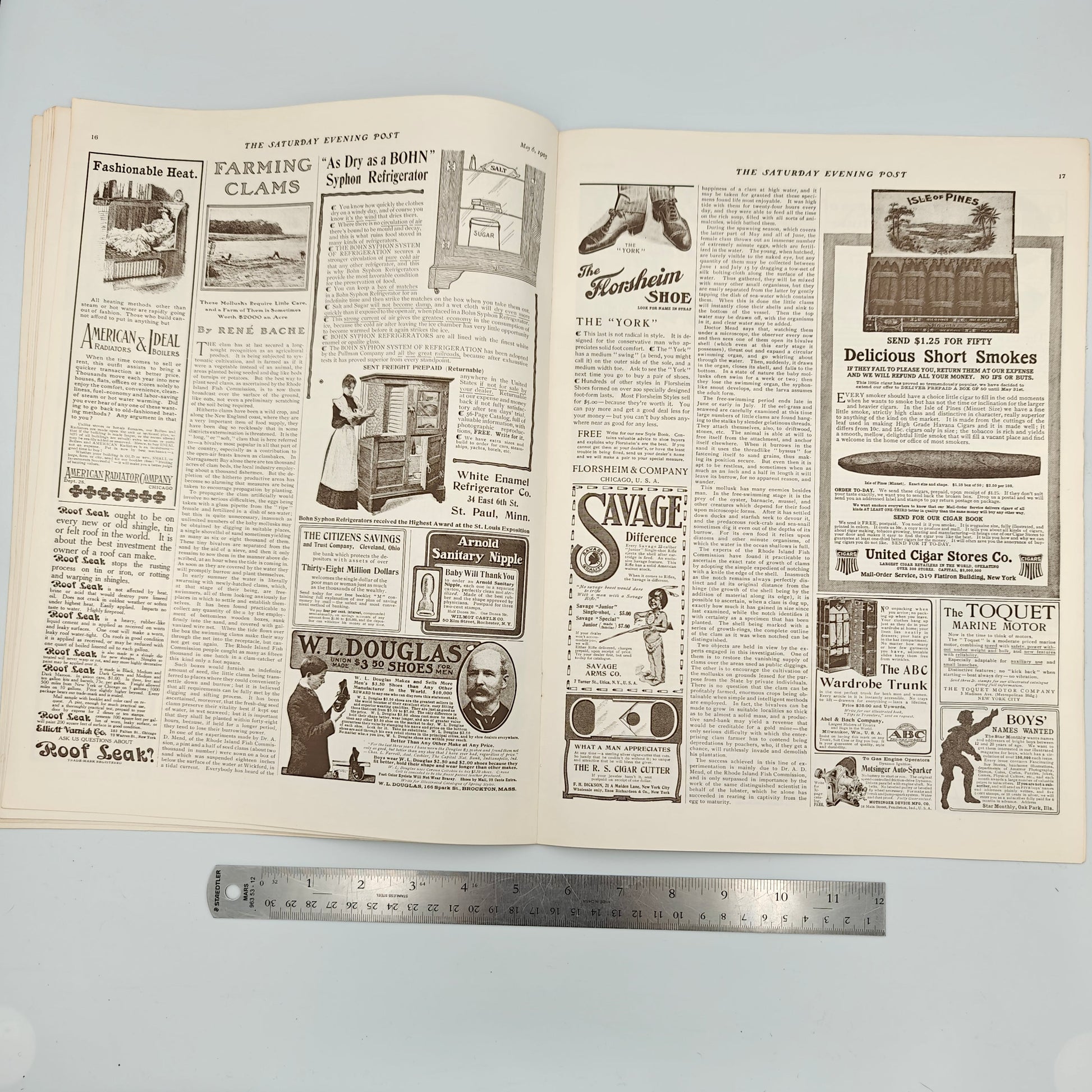 Open newspaper with visible text and images on a light gray background. Featuring ads like Fashionable Heat by American Radiator Co., Roof Leak, Bohn Syphon Refrigerator by White Enamel Refrigerator Co, Citizen's Savings and Trust Company, Arnold Sanitary Nipple, W.L. Douglas $3.00 Shoes, The Florsheim Shoe Co., Savage Arms Co., The R.S. Cigar Cutter, Isle of Pines by United Cigar Stores Co., The ABC Wardrobe Trunk by Abel &amp; Bach Co., The Toquet Marine Motor, Motsinger Mfg. Co. Auto-Sparker, Boys' Names