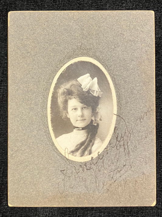 Vintage portrait of a woman with a bow in her hair on a textured gray background