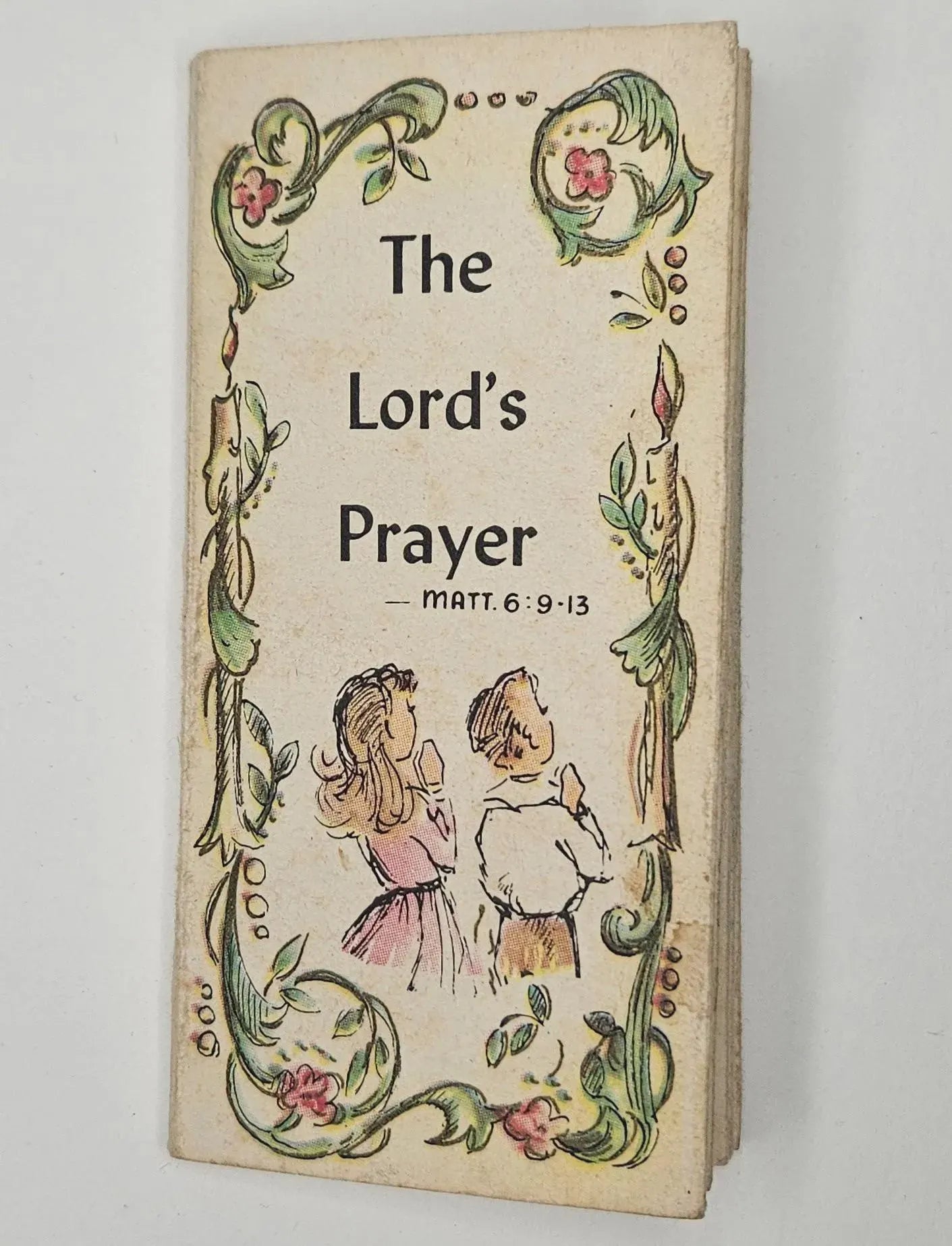 Vintage book cover with 'The Lord's Prayer' text and illustrations of two children on a white background