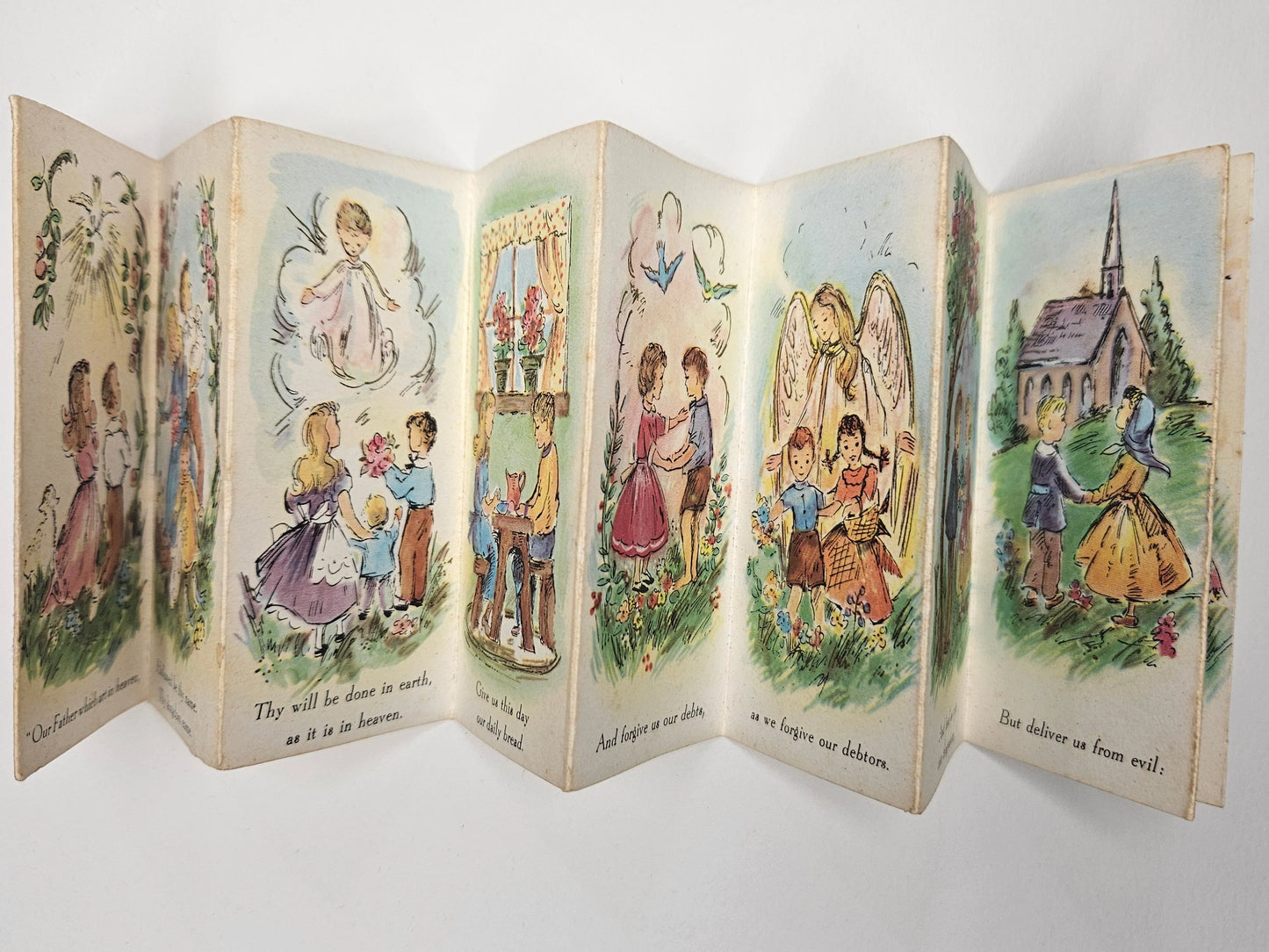 Vintage book with illustrated scenes of children and angels on a white background