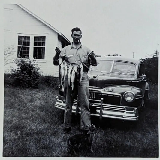 Black and White Photo of A New Car, a Cigarette, and a Bunch of Fish