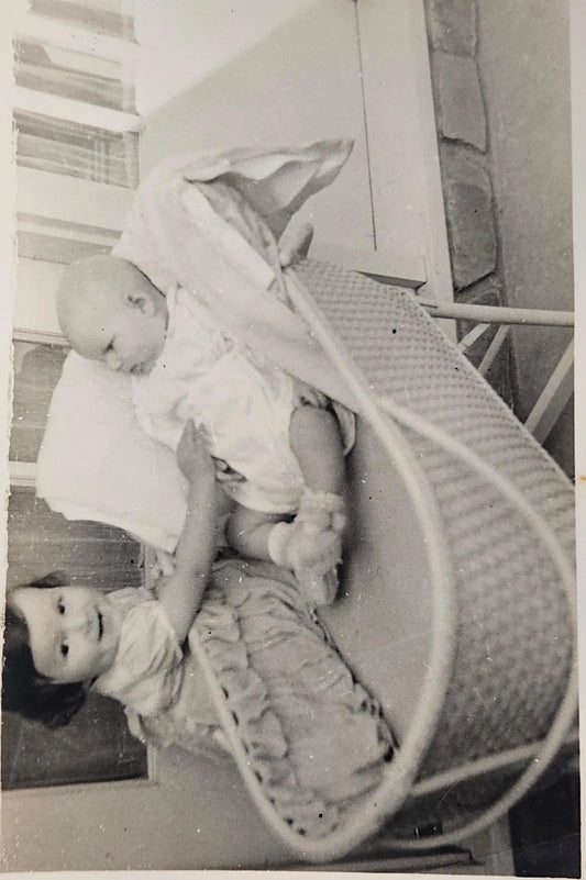 Black and White Photo of Smiling Toddler Meeting Baby Brother in Cradle, 1950s - Classic Family Photo of  Children - LaCrosse Wisconsin