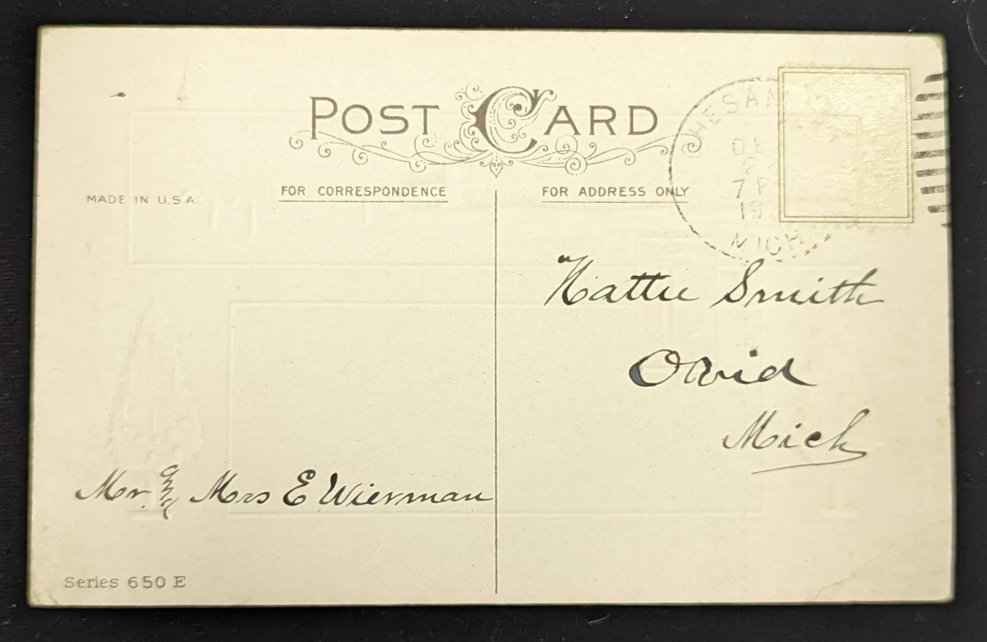 Vintage postcard with handwritten address on a black background