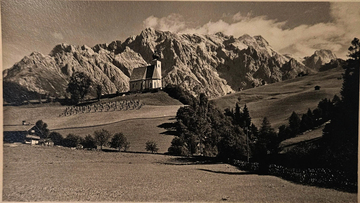 Vintage photograph of a train on a mountain pass with a scenic landscape.