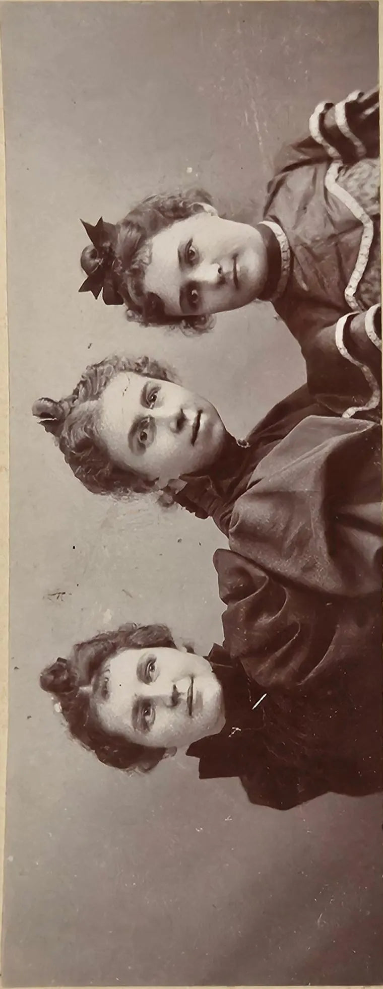 Three women posing together in a vintage 1890s portrait
