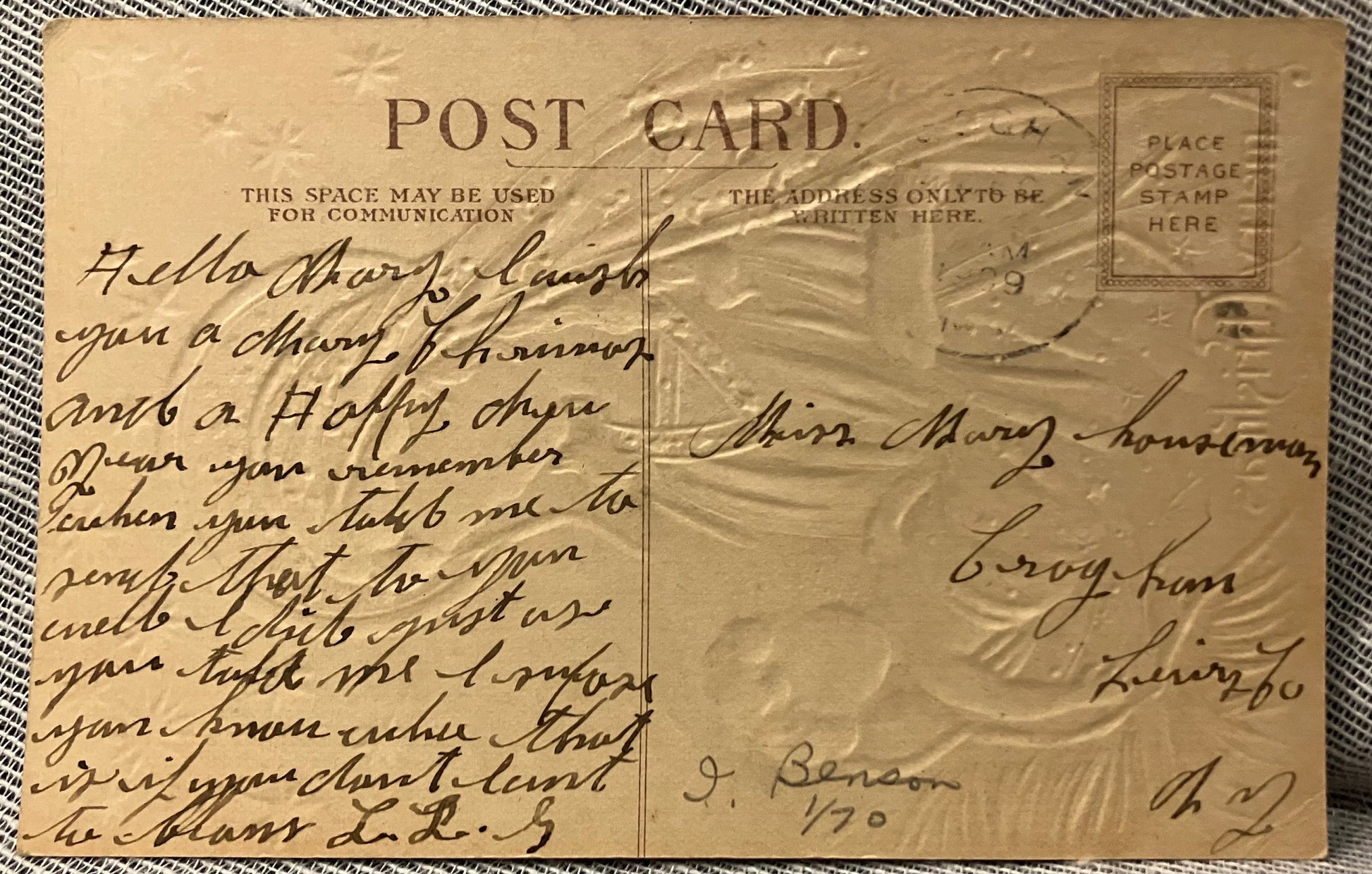 Vintage postcard with handwritten text and postage stamp on a textured surface