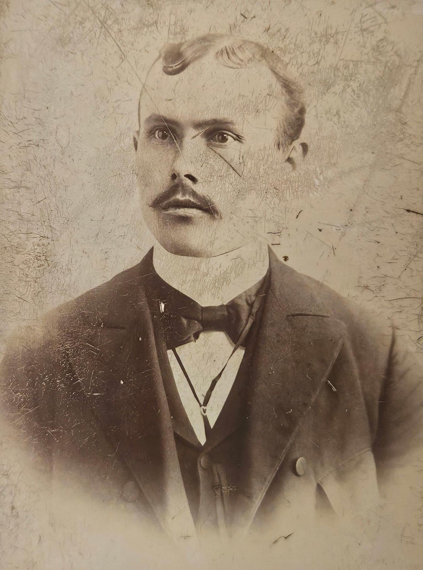 Vintage portrait of a man with a mustache and formal attire against a textured background