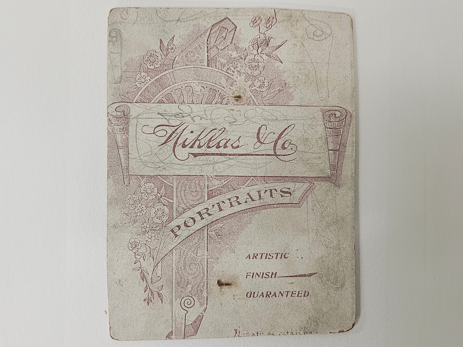 Vintage photograph back with decorative text and design on a white background