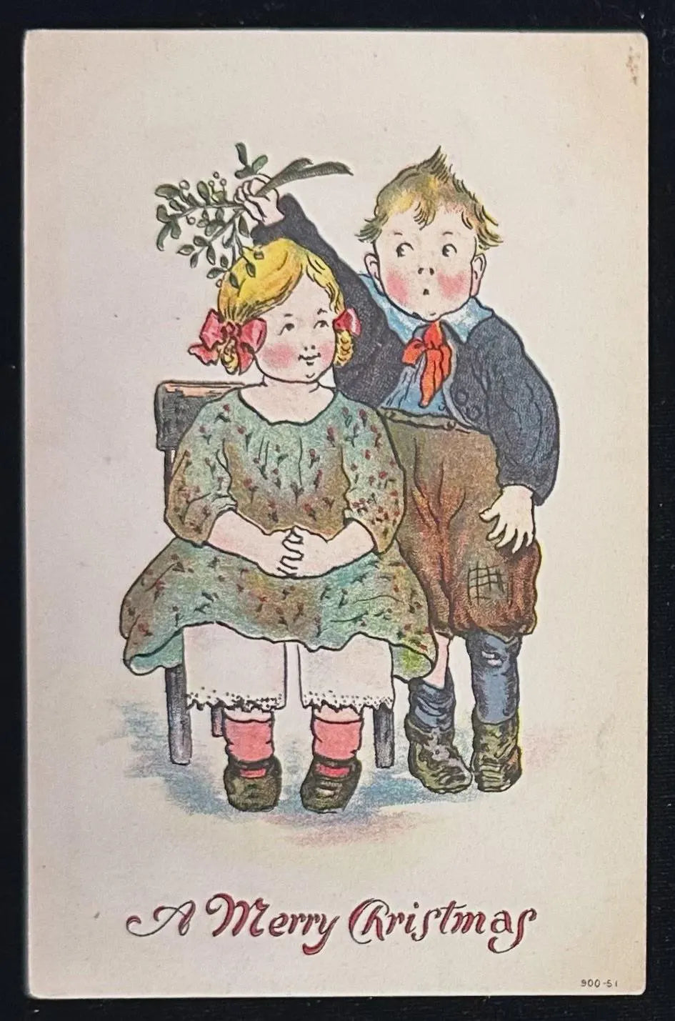 Vintage Christmas card with children holding mistletoe, text 'A Merry Christmas'.
