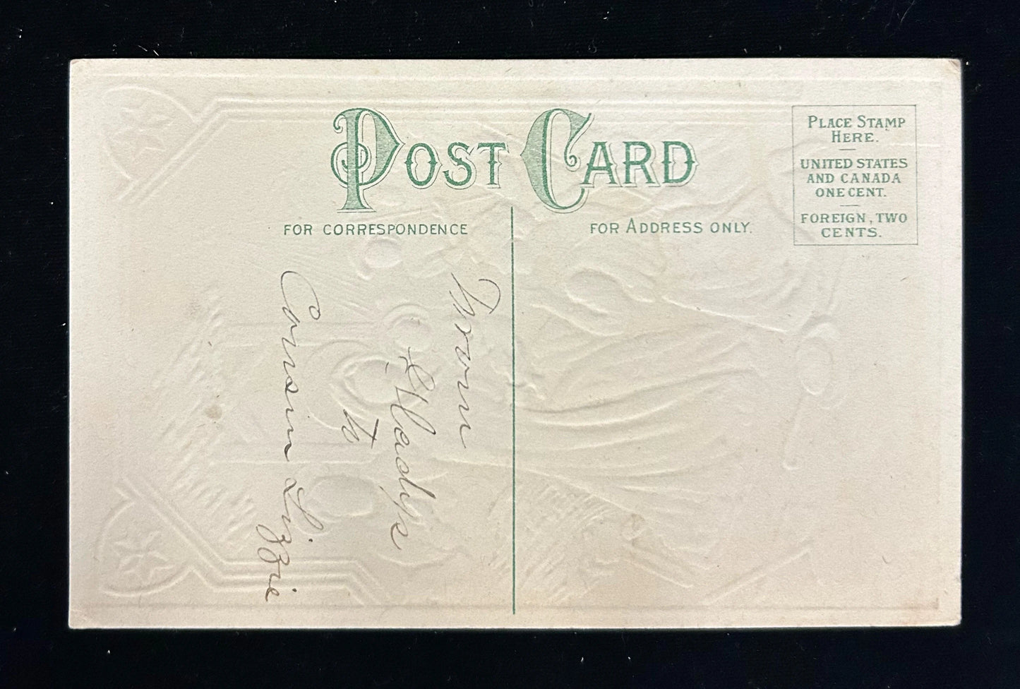 Vintage postcard with embossed design and text on a black background