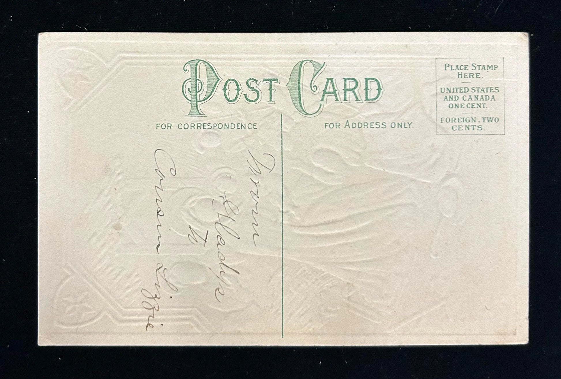 Vintage postcard with embossed design and text on a black background
