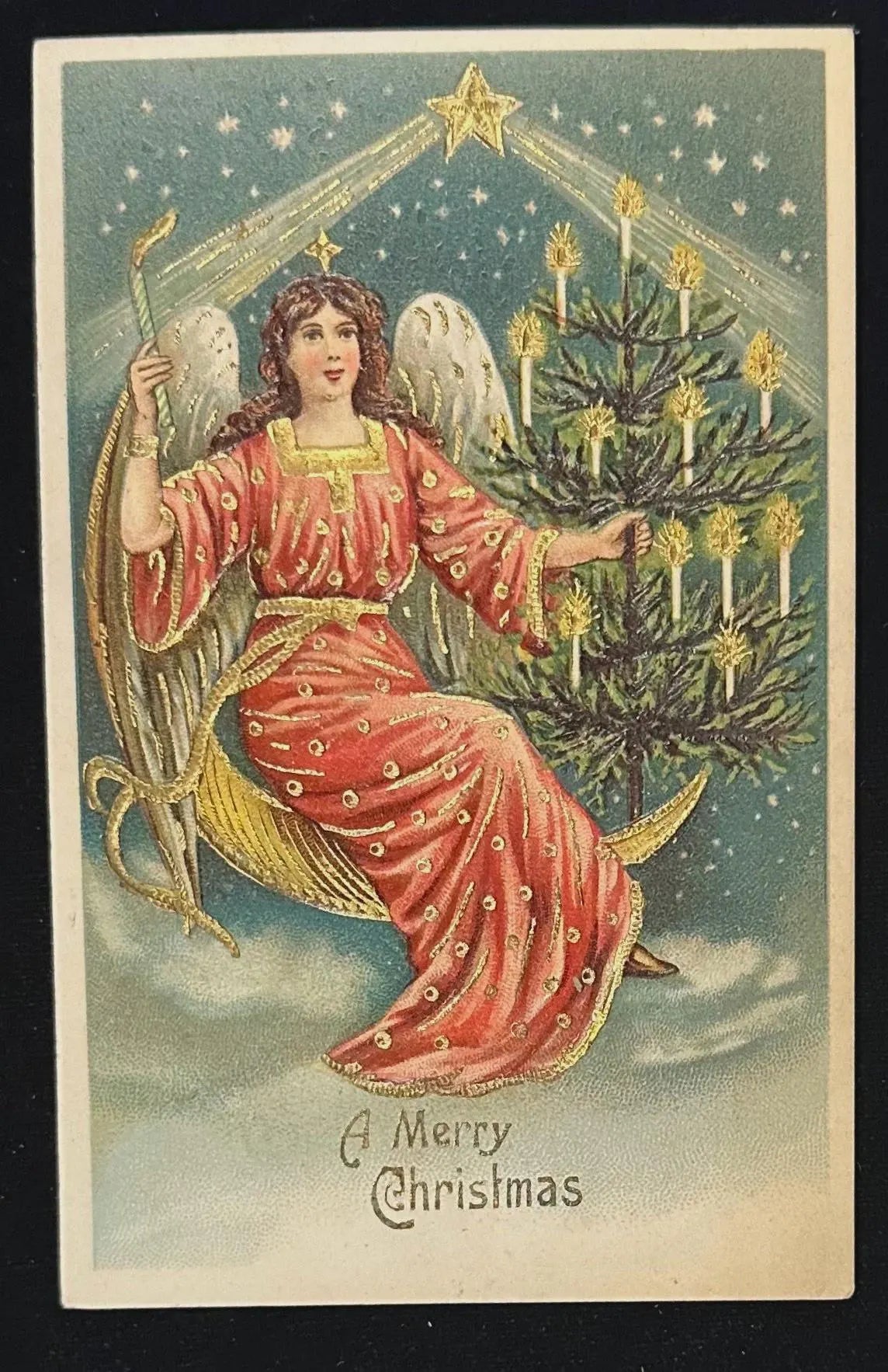 Vintage-style Christmas card with an angel and decorated tree, featuring 'A Merry Christmas' text.