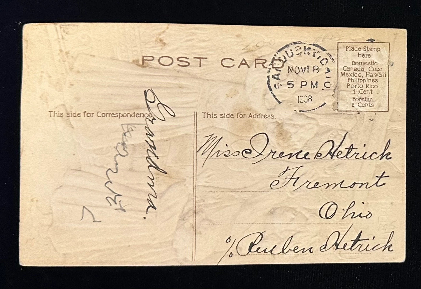 Vintage postcard with handwritten text and postage stamp on a dark background