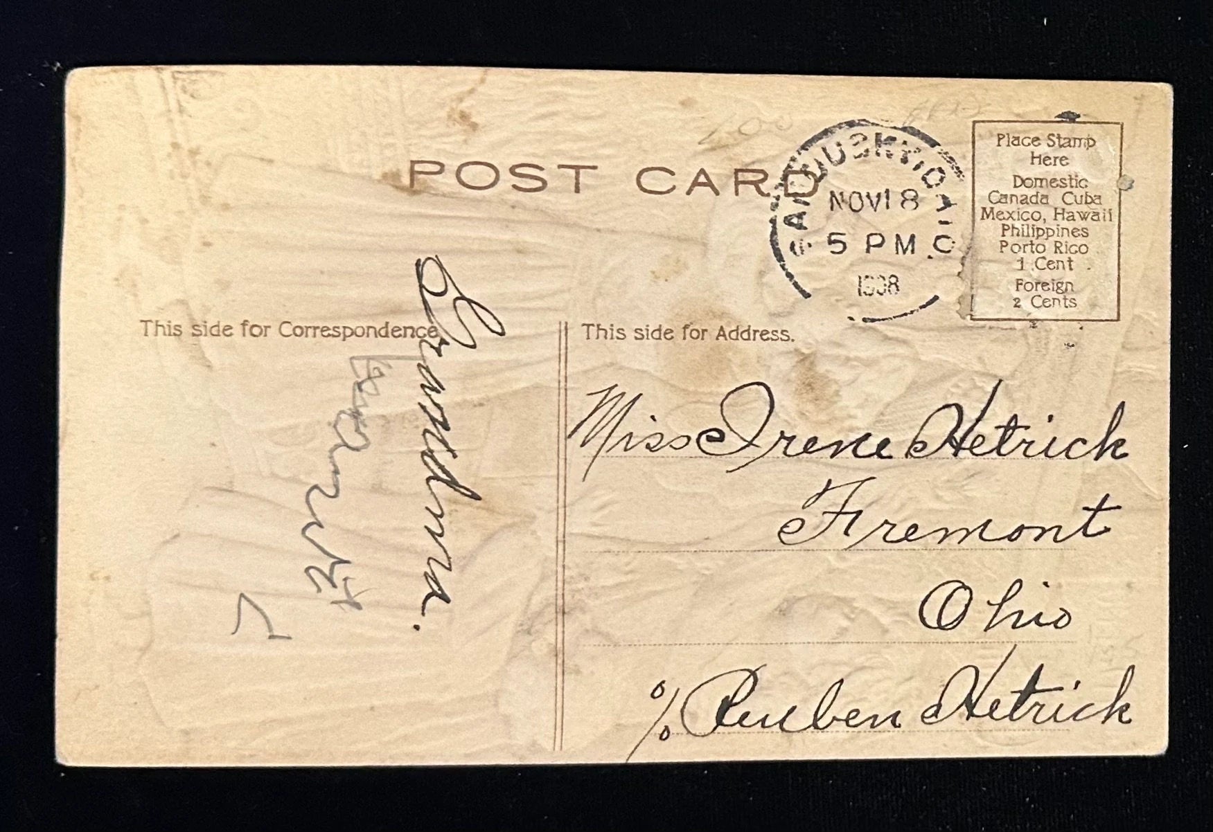 Vintage postcard with handwritten text and postage stamp on a dark background