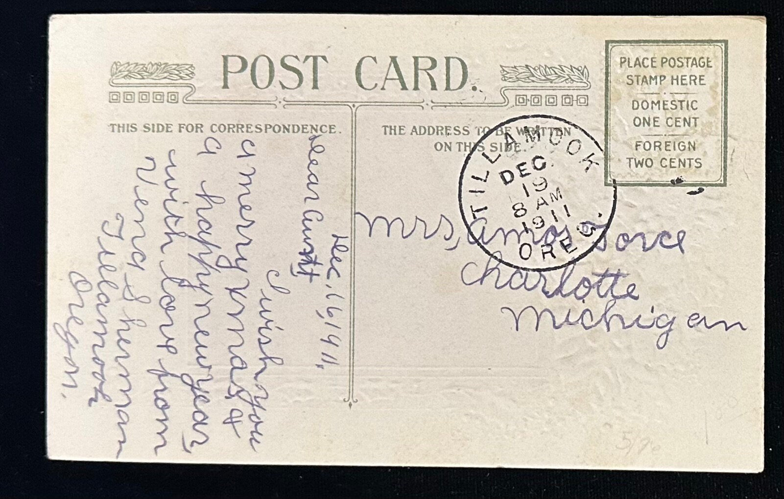 Vintage postcard with handwritten text and a stamp, on a black background