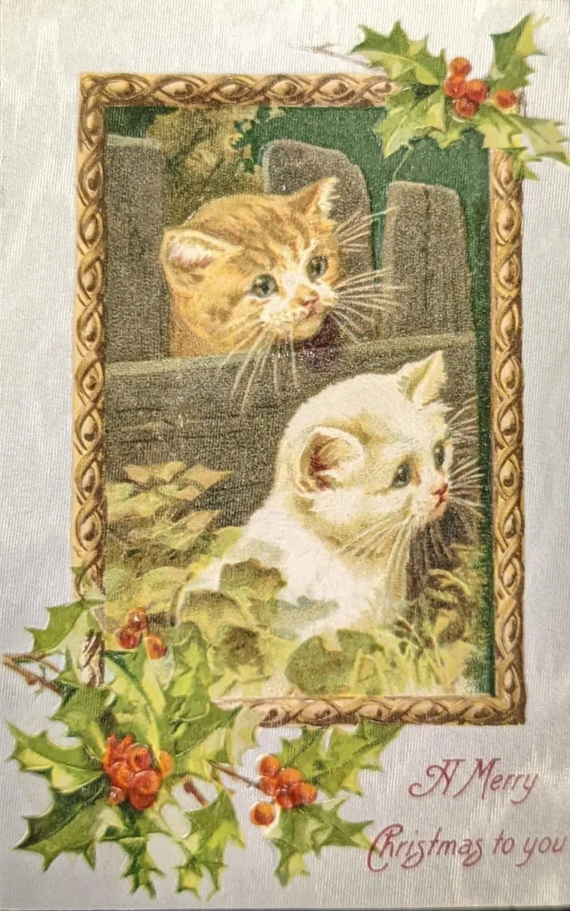 Vintage-style Christmas card with two cats and holly leaves.