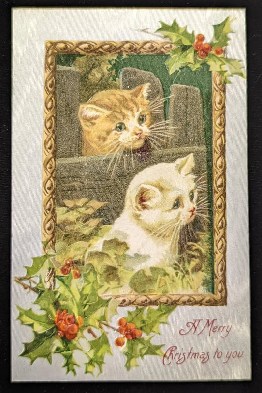 Vintage-style Christmas card with two cats and holly leaves.