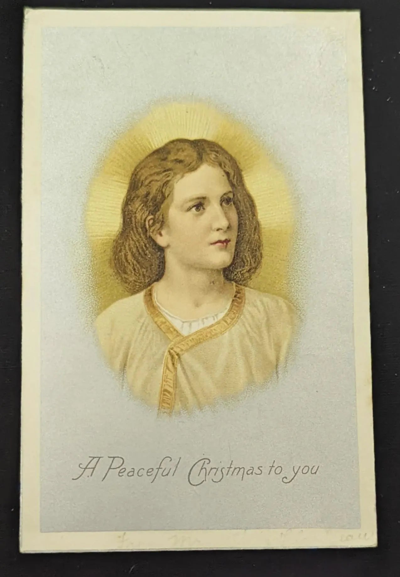 Vintage Christmas card with a woman's portrait and 'A Peaceful Christmas to you' text.