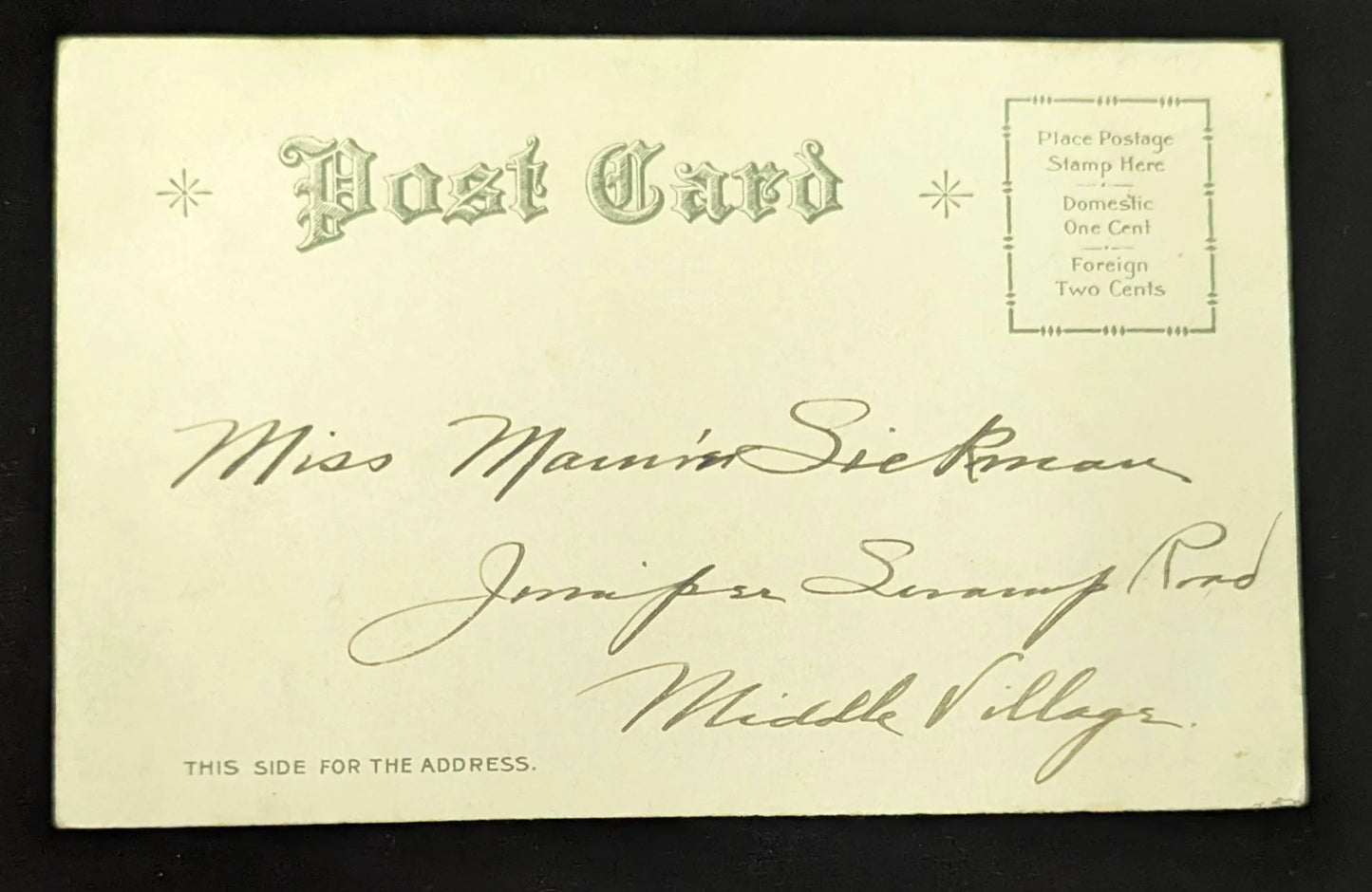 Vintage postcard with handwritten address on a black background