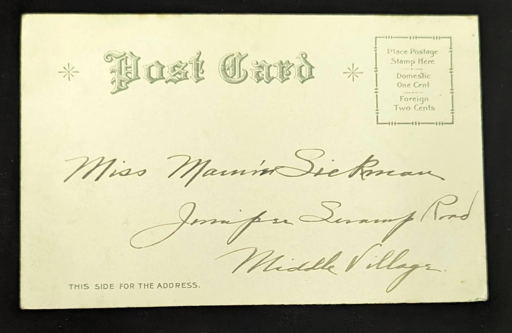Vintage postcard with handwritten address on a black background