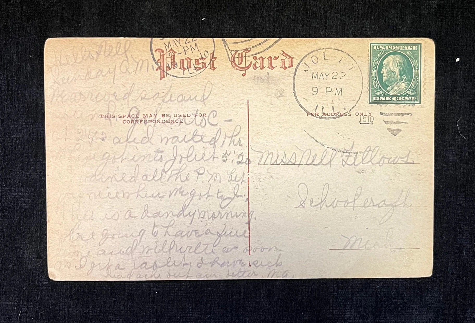 Vintage postcard with handwritten text and a stamp on a dark background