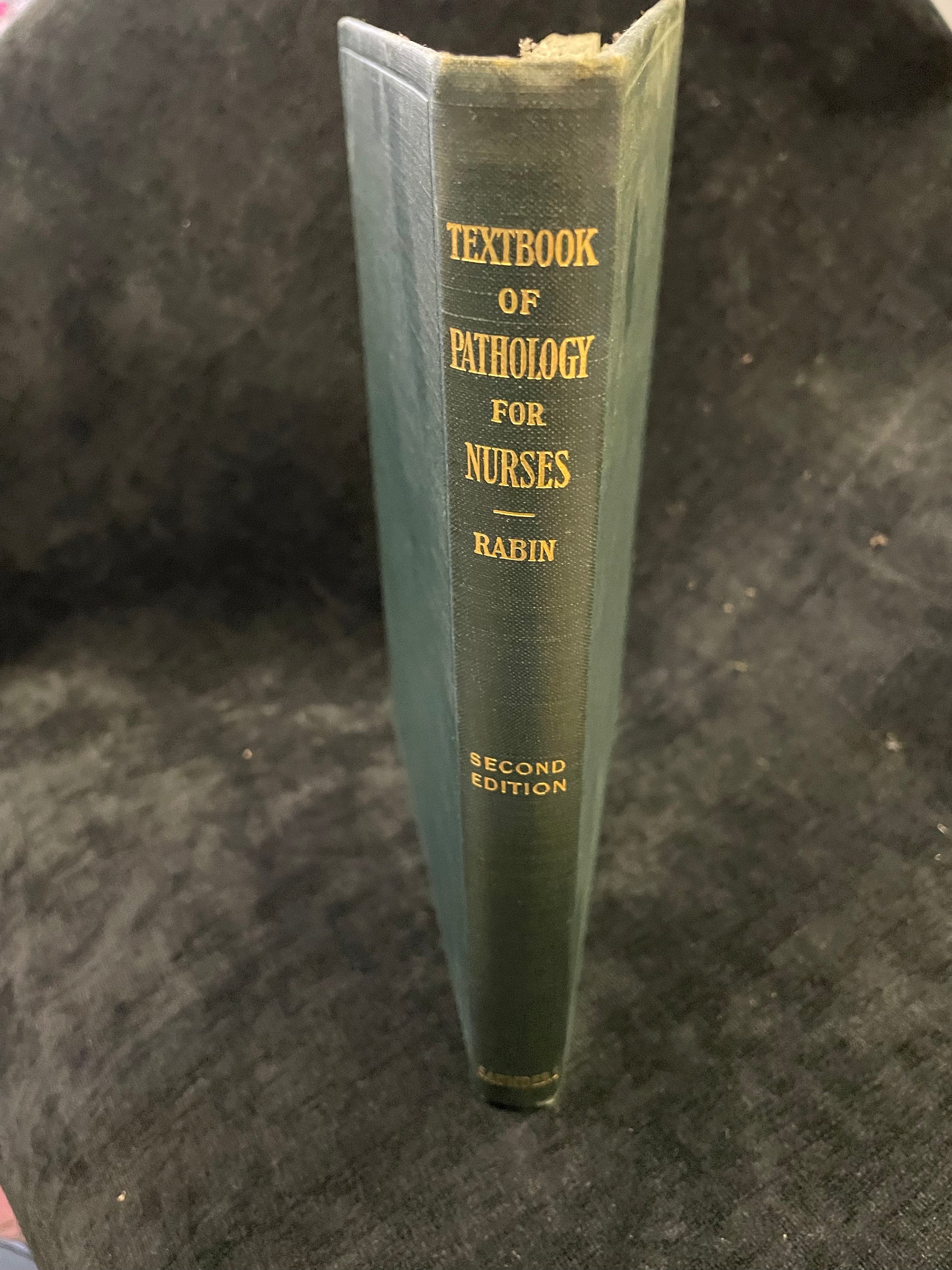 Textbook of Pathology for Nurses by Rabin on a dark textured background