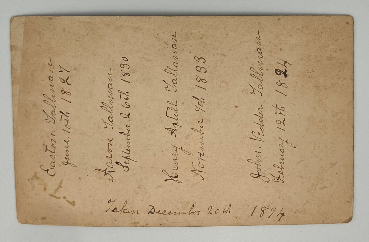 An antique handwritten paper document or receipt card with cursive ink writing on aged beige paper, photographed flat against a light neutral background.