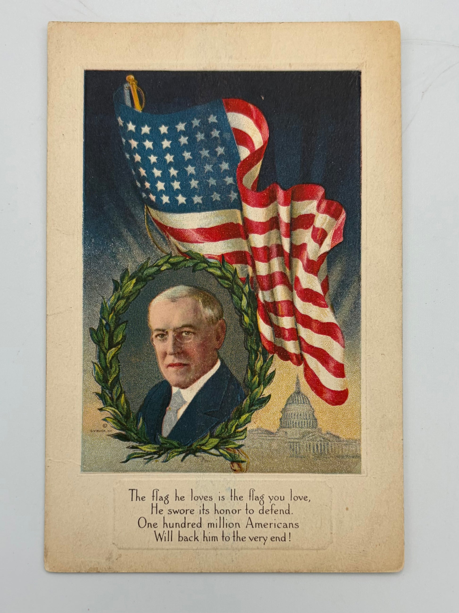 A vintage patriotic print or postcard featuring a portrait of historical American figure Woodrow Wilson framed by a green wreath, with a large waving American flag and the U.S.