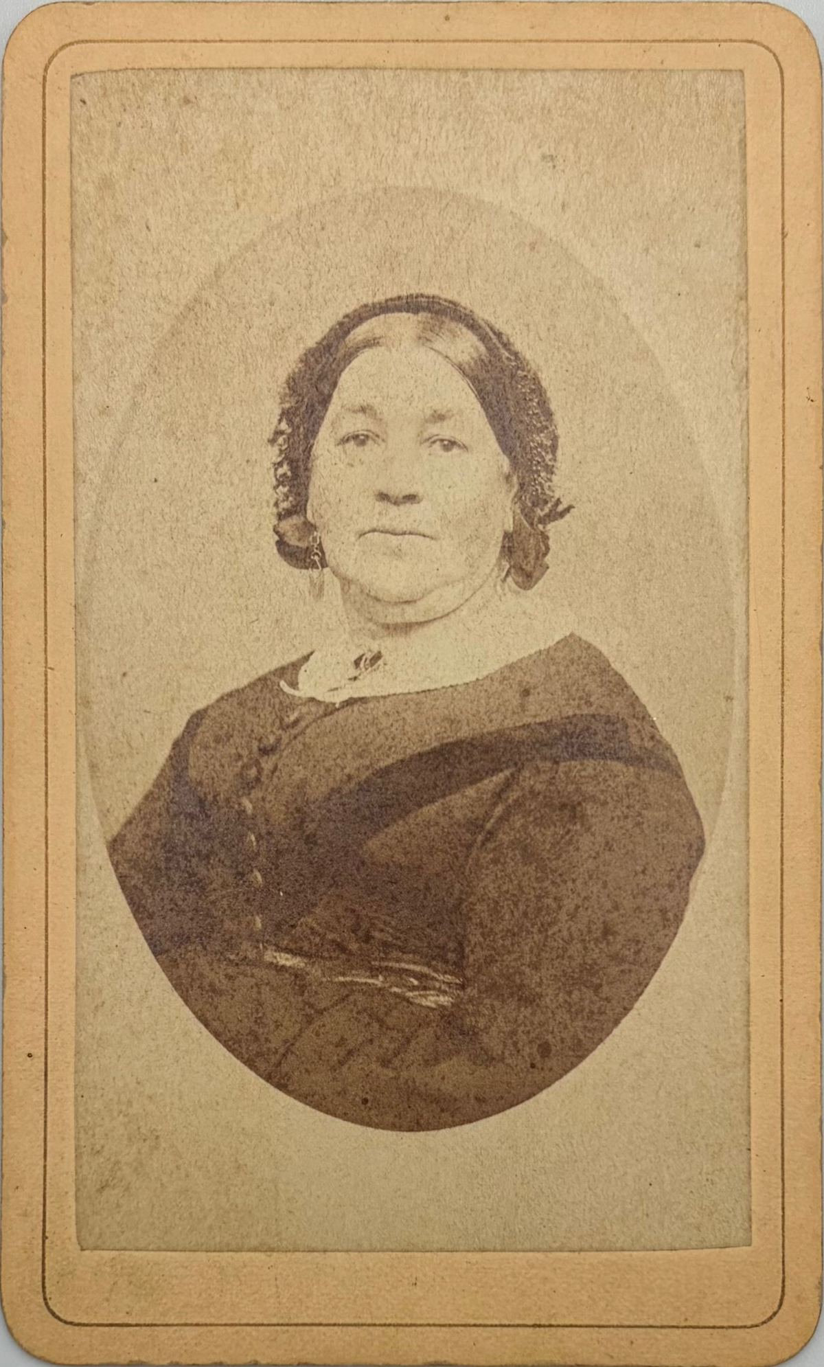 An antique cabinet card photograph print of a woman in a dark dress, showing aged sepia-toned paper with a tan border.