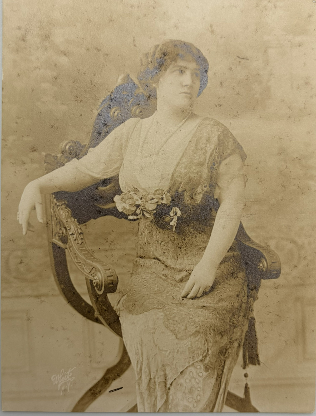 Vintage sepia-toned portrait photograph of a seated woman in an ornate chair