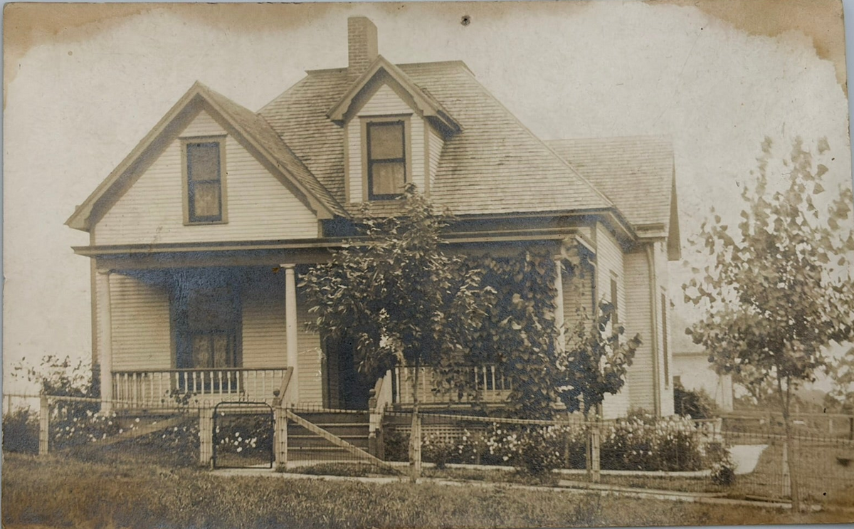 A vintage sepia-toned photograph print of a house