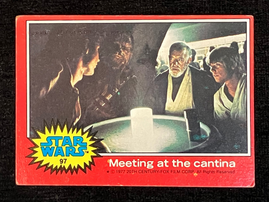 A vintage 1997 Star Wars trading card titled 'Meeting at the cantina' with a red border, yellow starburst logo, and a dark sci-fi scene printed on the front, photographed against a black textured background.