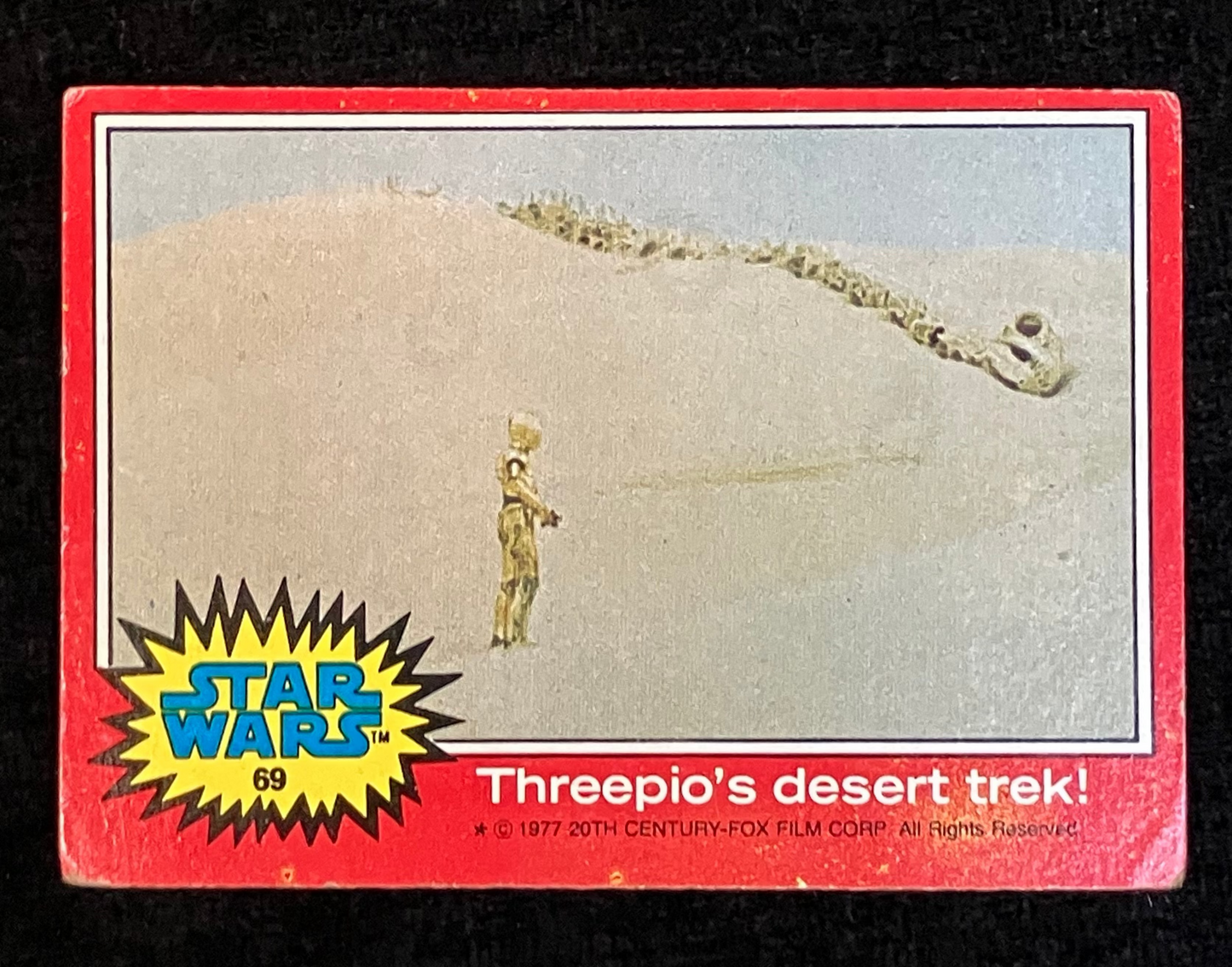 Vintage trading card featuring a desert scene with a Star Wars character.