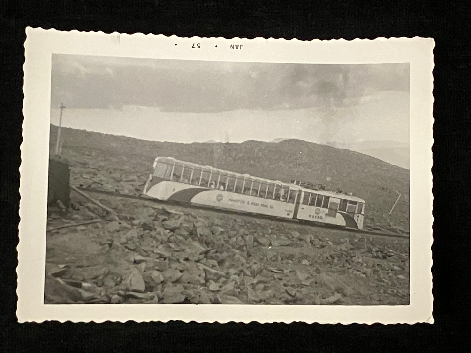 Black and white photo of train in mountains. 