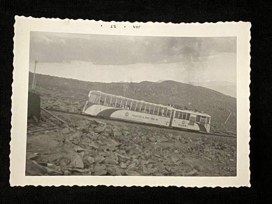 Black and white photo of train in mountains. 
